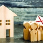 A crowd of wooden toy people protests against the rising cost of services near a wooden house. Strike against high prices. The decline in living standards, social tension and an angry mob.