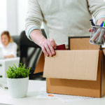 Upset office manager packing the box and leaving the office