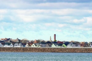 Smokestack and church steeple stand out over New Bedford neighborhood behind hurricane protection barrier