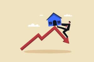 Property and housing market collapse, real estate stock risk. Home prices fall in real estate and property market crash. A businessman tries to keep the house from falling off the top of the graph price.