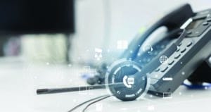 close up headset of call center and VOIP communication with futuristic virtual icon telecommunication technology on office table in monitoring room for network operation job concept