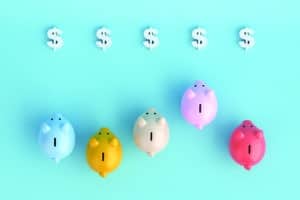 Colorful piggy banks racing towards dollar signs. 