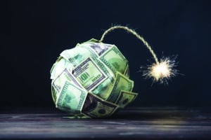 A big bomb made of hundred dollar bills with a burning fuse.