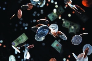 Studio shot of falling coins falling through the air in front of a black background