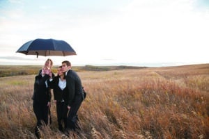 Business people under umbrella in rural field