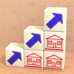 3D illustration of cubes with arrow and houses symbols stacked in a pyramid, with arrows pointing up