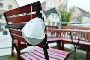 FFP2 mask hangs on a chair in an empty beer garden in Steyr, Austria, Europe