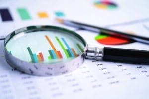Magnifying glass on charts graphs paper. Financial development, Banking Account, Statistics, Investment Analytic research data economy, Stock exchange trading, Business office company meeting concept. spreadsheets earnings spreadsheet