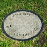 Round concrete lid on a electrical pit on a nature strip marked with Electrical, Melbourne, Australia, 2015