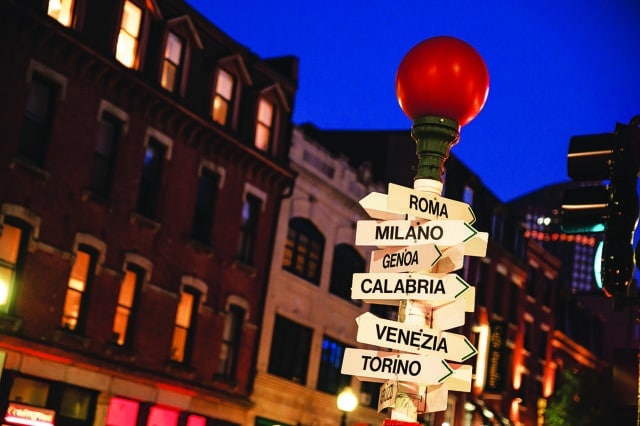 Sign post points the directions of other cities from Boston's North End on a summer evening.