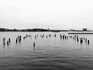 The remains of a pier in Boston’s North End poke above the water in Boston Harbor.