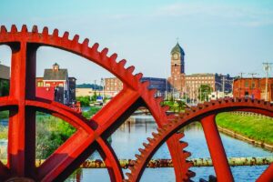 Lawrence’s Ayer Mill is seen through the gears of an old canal sluice gate.