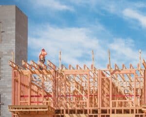 Construction site of upscale apartment building in North Dallas, Texas, USA. Five-story luxury condos with large patio, elevator shaft. Unidentified worker with tool belt and safety equipments working