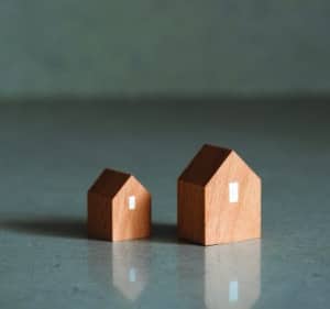 Miniature houses on grey background.