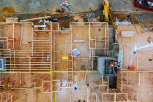 Aerial view of brick builders are building walls in elevator shaft in residential apartments under construction