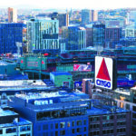 An aerial view of Fenway Park, the historic home of the Boston Red Sox, nestled amidst the cityscape of Boston. The iconic ballpark stands out with its distinctive green facade and the famous "Green Monster" left field wall. The surrounding cityscape provides a vibrant backdrop, highlighting the stadium's integration into the urban fabric of Boston. The image captures the timeless charm of Fenway Park, a beloved landmark and a symbol of baseball history.
