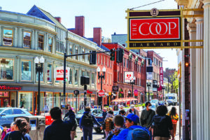 Cambridge, MA, US-May 1, 2025: Street scence in Harvard Square district with people walking by the Harvard Coop, Harvard University's bookstore.