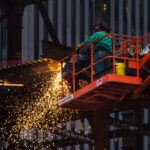 Workers in a cherry-picker welding steel beams and columns in Lower Manhattan in 2017